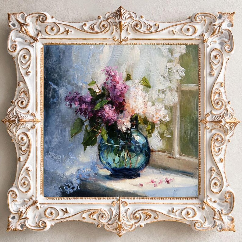 May include: An oil painting in a white and gold ornate frame depicting a bouquet of purple and white lilacs in a round blue glass vase. The flowers sit on a surface near a window with soft light, featuring visible brushstrokes and textures.