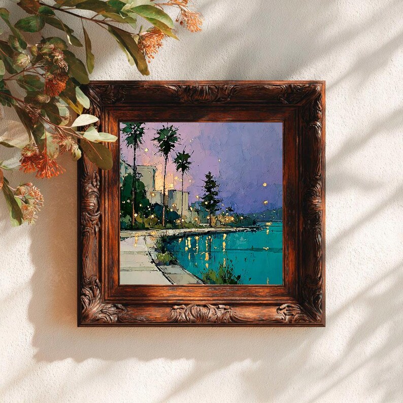 May include: A framed landscape painting depicts a coastal scene at dusk. The artwork features palm trees, buildings, and a body of water with reflections. The frame is ornate, with a dark brown finish. The painting's colors include teal, purple, and yellow.