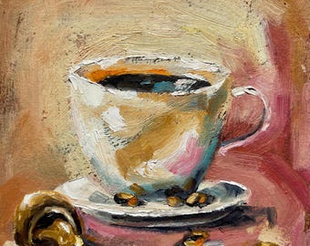 May include: A white coffee cup with a brown handle sits on a white saucer with coffee beans scattered around it. The cup is filled with dark brown coffee. The background is a soft pink and yellow.