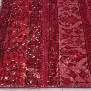 K&ouml;nnte beinhalten: Ein roter und rosafarbener Vintage-Teppich mit einem floralen Muster. Der Teppich hat einen Fransenrand und ist aus Wolle.