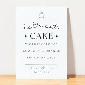 Puede incluir: Un letrero blanco con las palabras "let's eat CAKE" y una ilustración de pastel. Enumera los sabores de pastel: Victoria Sponge, Chocolate Orange y Lemon Drizzle. El letrero está firmado "Olivia & Thomas" con la fecha 24.10.2026.