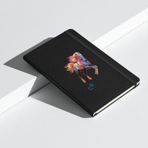 May include: Black notebook with a colorful horse illustration and the letter "S" in a blue circle on the cover.
