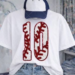 May include: White t-shirt with a baseball-themed design featuring the number "10" in red and white. The number is styled with baseball stitching. A white and navy blue baseball cap is on top.
