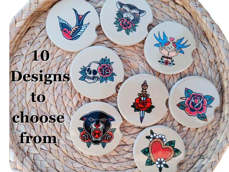 May include: Ten different designs of round drink coasters with various tattoo-inspired images. The coasters are beige with a white background and feature images of a skull, a panther, a rose, a dagger, a bird, a heart, and a cat. The text "10 Designs to choose from" is visible in the image.