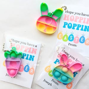May include: Three Easter-themed gift tags with colorful pop-it fidget toys attached. The tags say "Hope you have a Hoppin Poppin Easter" and "From:".