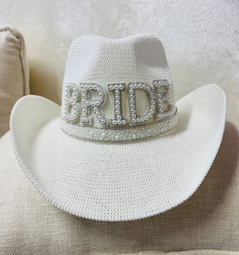 May include: White cowboy hat with a pearl embellished "BRIDE" band.