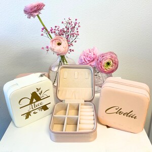 Pode incluir: Tr&ecirc;s caixas de joias cor-de-rosa com letras douradas. As caixas s&atilde;o personalizadas com os nomes "Alice", "Clodin" e uma &uacute;nica inicial "A".