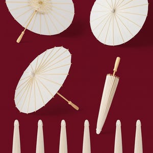 May include: A collection of white paper parasols with wooden handles, set against a deep red backdrop. Some are open, revealing their circular design, while others are closed, showing their elongated shape. These decorative parasols are suitable for weddings or special events.