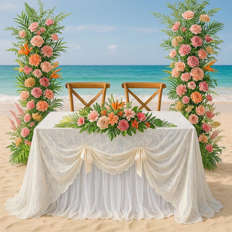 May include: A beach wedding setup with a white lace-covered table, two wooden chairs, and floral arrangements. The table is decorated with a floral centerpiece and the backdrop is the ocean and sky.