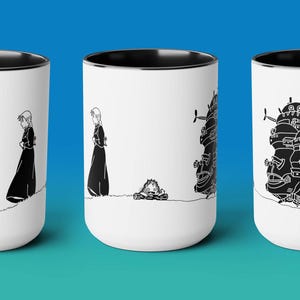 May include: Set of three white ceramic mugs with black handles and black interior. Each mug features a black and white illustration from the animated film 'Howl's Moving Castle'. The first mug shows the characters Sophie and Howl walking away from each other. The second mug shows Howl's Moving Castle. The third mug shows Sophie and Howl walking towards each other.