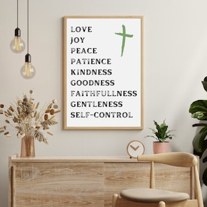 Puede incluir: Una impresión enmarcada en blanco con texto negro que enumera los frutos del espíritu: amor, alegría, paz, paciencia, bondad, amabilidad, fidelidad, gentileza y dominio propio. Una cruz verde está centrada en la impresión.