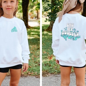 May include: White sweatshirt with a teal blue graphic of a turtle with the word "SWIM" on the front and the text "EAT MY BUBBLES" with teal blue bubbles on the back.