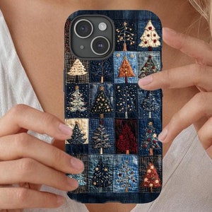 May include: A phone case with a patchwork design featuring a variety of blue denim fabrics and embroidered Christmas trees. The case has a cutout for the camera lens and a black border.