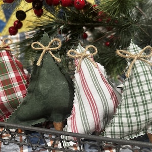 Pu&ograve; includere: Quattro decorazioni natalizie a forma di albero in tessuto all'interno di un cestino in filo metallico. Ogni albero presenta un motivo diverso: tartan rosso e verde, verde scuro tinta unita, bianco a righe rosse e bianco a quadri verdi.