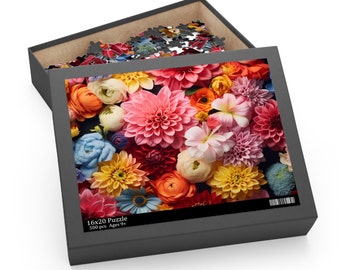 May include: A 500-piece jigsaw puzzle in a black box featuring a vibrant floral arrangement of dahlias and ranunculus in shades of pink, orange, yellow, and blue. The box lid displays the text 16x20 Puzzle 500 pcs Ages 9+ with a barcode.
