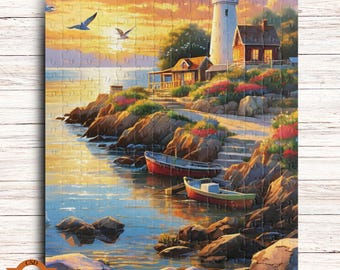 May include: A completed jigsaw puzzle showing a coastal scene with a lighthouse, boats, and seagulls. The puzzle features a white lighthouse with a red top, a small house, and two boats in the water. The sky is a mix of orange, yellow, and blue.
