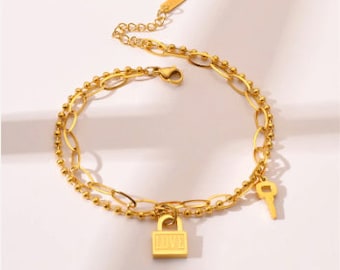 Pulsera dorada con dije de llave y candado