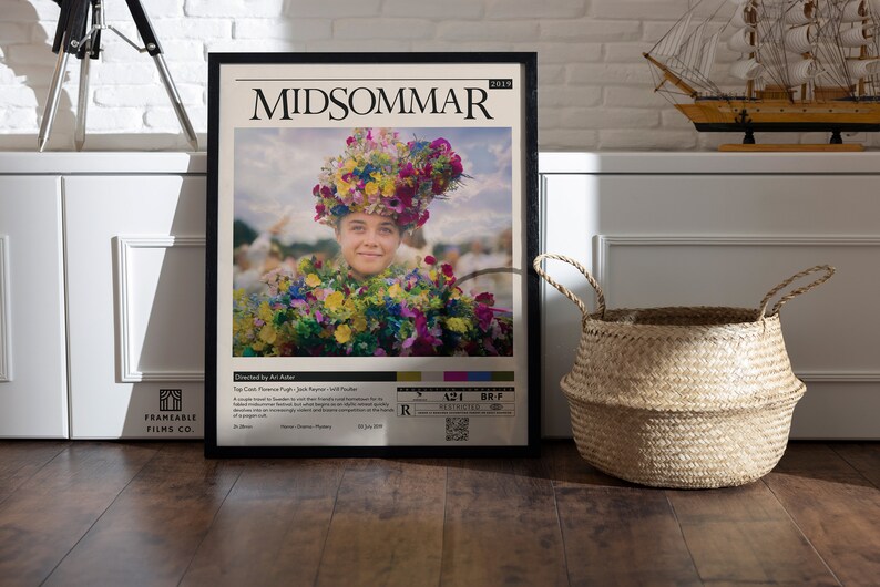 May include: A movie poster for the film "Midsommar" (2019) featuring a young woman wearing a flower crown and a floral dress. The poster is framed in black and has a white background with the film title and director's name printed in black.