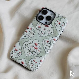 Puede incluir: Una funda para teléfono verde y blanca con un patrón floral y flores rojas. La funda está diseñada para un iPhone 14 Pro Max.