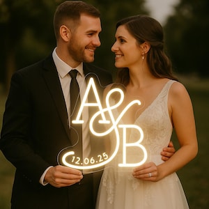 May include: A neon sign with the letters "A & B" and the date "12.06.25" in a cursive font. The sign is held by a couple, the man in a black suit and the woman in a white wedding dress. The sign glows with a warm, soft light.