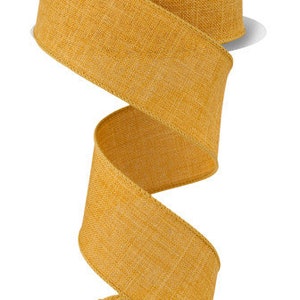 May include: A spool of 2.5 inch wide, mustard yellow, woven ribbon. The ribbon has a textured, linen-like appearance.