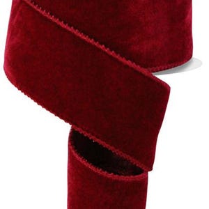 May include: A spool of 2.5 inch wide burgundy velvet ribbon. The ribbon is soft and has a slight sheen.