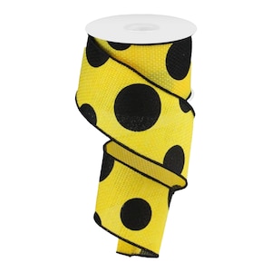 May include: A spool of yellow ribbon with large black polka dots. The ribbon has a textured appearance and is rolled around a white cardboard core. The edges of the ribbon are finished with a black trim.