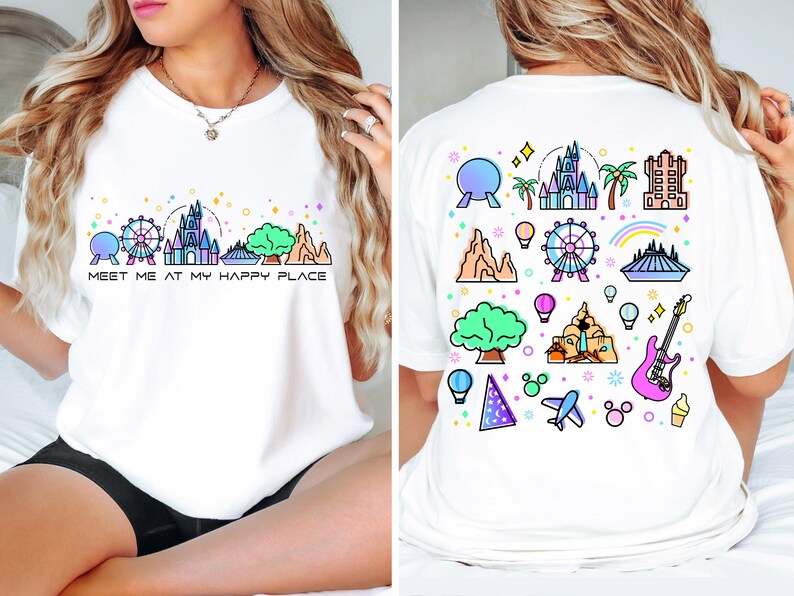Op de afbeelding: Wit T-shirt met een kleurrijke afbeelding van Disney World-bezienswaardigheden aan de voor- en achterkant. De afbeelding aan de voorkant zegt "Meet me at my happy place".