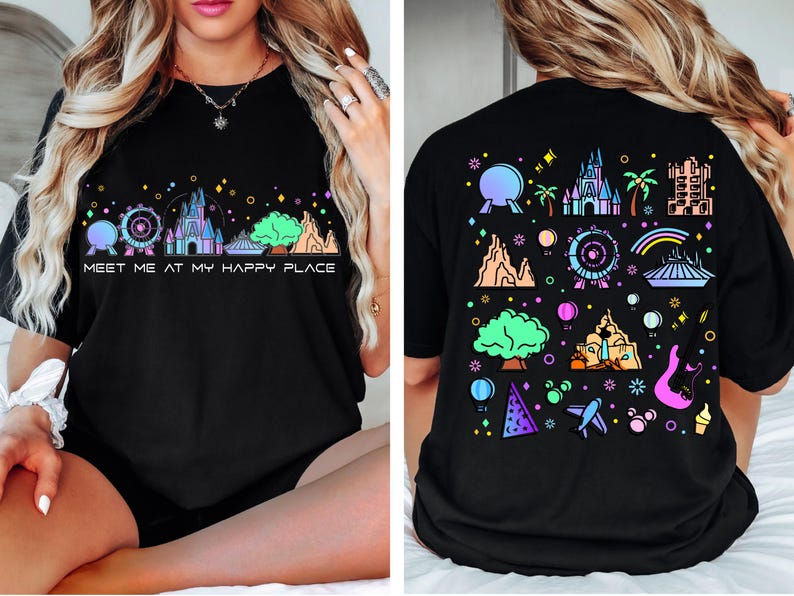 Op de afbeelding: Zwart T-shirt met een kleurrijke afbeelding van een Disney-themapark skyline en de tekst "Meet me at my happy place".