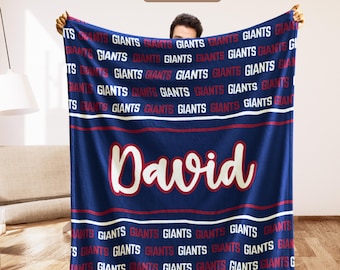 May include: A navy blue blanket with the word "David" in white script, and the word "GIANTS" repeated in red and white. The blanket has red and white stripes and the text "Custom team" at the top.