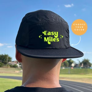 May include: Black 5-panel hat with a mesh back and a neon green "Easy Miles" logo with stars on either side.