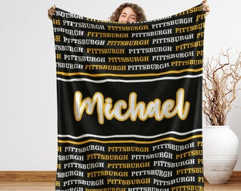 May include: Black blanket with the name "Michael" in yellow script. The word "Pittsburgh" is repeated in white and gold. The blanket has white and gold stripes.