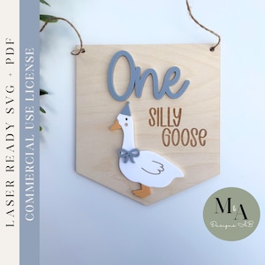 May include: A wooden sign with a gray goose wearing a party hat and a bow. The sign says "One Silly Goose".