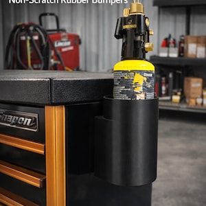 May include: Black magnetic torch holder with a yellow and black torch bottle. The holder has a 272 kg magnetic pull force and non-scratch rubber bumpers. The text on the holder says "Made for most torch bottles."