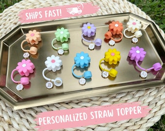 Puede incluir: Surtido de toppers de paja en forma de margarita de colores con abalorios de letras doradas. Los abalorios deletrean las letras A a J.  Topper de paja personalizado.