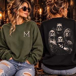Könnte beinhalten: Ein olivgrünes Sweatshirt mit Rundhalsausschnitt und einem gotischen Buchstaben M auf der Brust sowie ein schwarzes Sweatshirt mit einer großen kreisförmigen Grafik auf dem Rücken, die eine Mumie, Frankensteins Monster, einen Vampir und einen Werwolf zeigt.