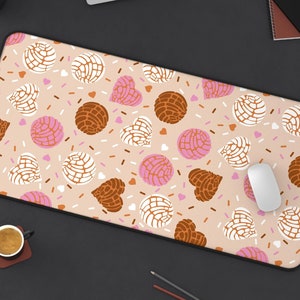 May include: A pink and brown patterned mouse pad with a white mouse on top. The pattern features a repeating design of hearts, sprinkles, and pastries.