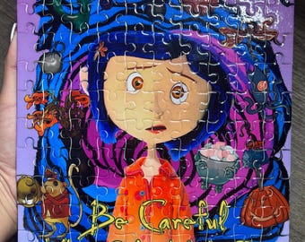 May include: A rectangular jigsaw puzzle featuring a central illustration of a character with blue hair and an orange coat. The background displays swirling blue and purple patterns with various small icons. The text reads Be Careful What You Wish For.