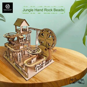 May include: A wooden 3D puzzle model of a jungle-themed rock bead roller coaster. The model features a winding track, a spiral ramp, and a large gear. The puzzle is hand-crafted and comes with the text "Jungle Hand Rock Beads" and "Hand Crafted".