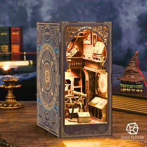 May include: A wooden book nook with intricate laser-cut details, featuring a miniature interior scene with a balcony, books, and a telescope. The book nook has a dark blue and gold cover with a circular design. A brown sorting hat sits atop a stack of books.