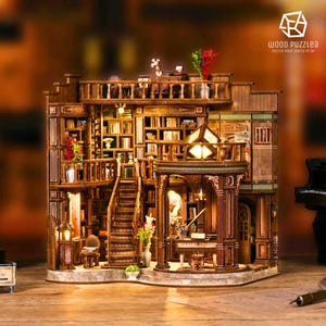 Puede incluir: Rompecabezas de madera detallado que representa una biblioteca de varios pisos con estanterías, escaleras y un balcón. El modelo presenta detalles intrincados, iluminación cálida y elementos decorativos.
