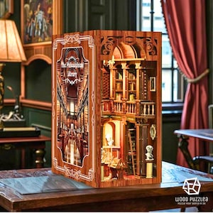 Puede incluir: Un rincón de libro de madera que presenta una escena de biblioteca detallada con libros en miniatura, estanterías y elementos arquitectónicos. El panel frontal muestra el texto "The Philosophical Library". El rincón del libro está iluminado.
