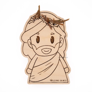 May include: A wooden cutout of a cartoon Jesus with a crown of thorns on his head. The cutout is unpainted and ready to be colored. The text "WOLFING SAINTS" is printed at the bottom of the cutout.
