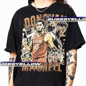 May include: Black t-shirt with a retro design featuring basketball player Donovan Mitchell. The graphic includes images of Mitchell in his Cleveland Cavaliers jersey, the name "DONOVAN MITCHELL", and the number 45.