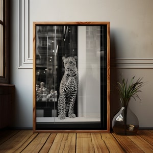 May include: A black and white photograph of a leopard looking out of a storefront window. The leopard is standing on a tiled floor and the window is framed in wood.
