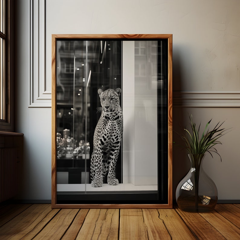 May include: A black and white photograph of a leopard looking out of a storefront window. The leopard is standing on a tiled floor and the window is framed in wood.