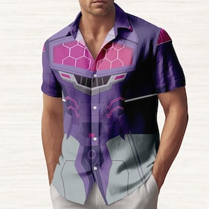 Puede incluir: Camisa morada y gris de manga corta con un diseño geométrico. La camisa presenta un gráfico detallado con tonos de morado, rosa y gris, creando una estética futurista o robótica. La camisa tiene un cuello clásico y cierre de botones.