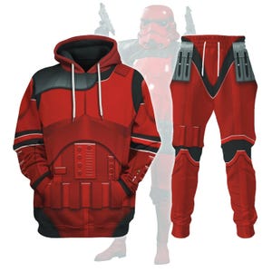 May include: A red hoodie and matching pants set. The hoodie features a detailed design with black accents and a hood with white drawstrings. The pants have a similar design with black details. The set is inspired by a sci-fi theme.