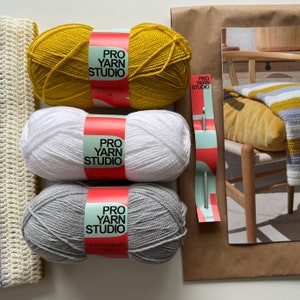 May include: Three balls of yarn in yellow, white, and gray colors. Each ball has a label that reads "Pro Yarn Studio" and "Premium Acrylic DK".
