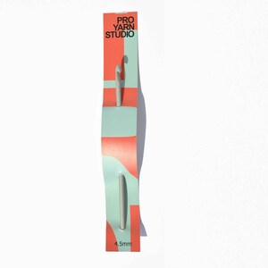 May include: A silver crochet hook with a 4.5 mm size label on a pink and blue packaging card with the text "Pro Yarn Studio".
